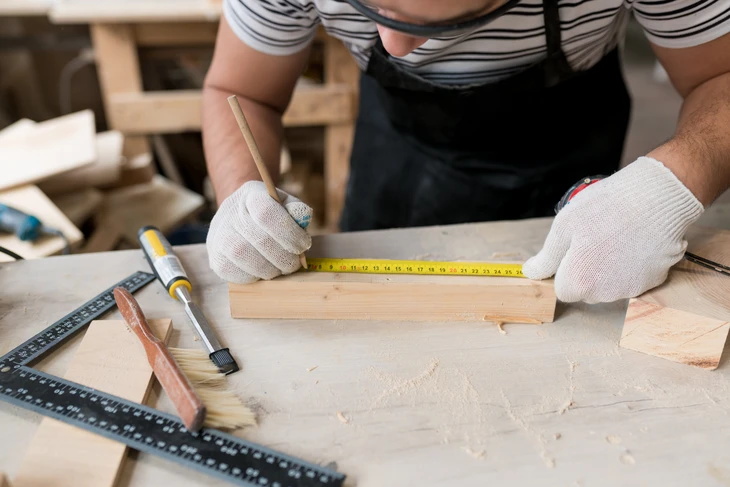 Artisanat, fabricant de meubles et assembleur, installe une cuisine moderne dans la maison avec des outils à la main